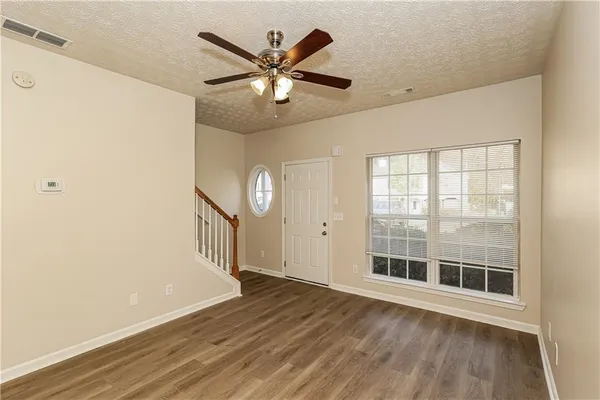 an empty room with wooden floor and windows