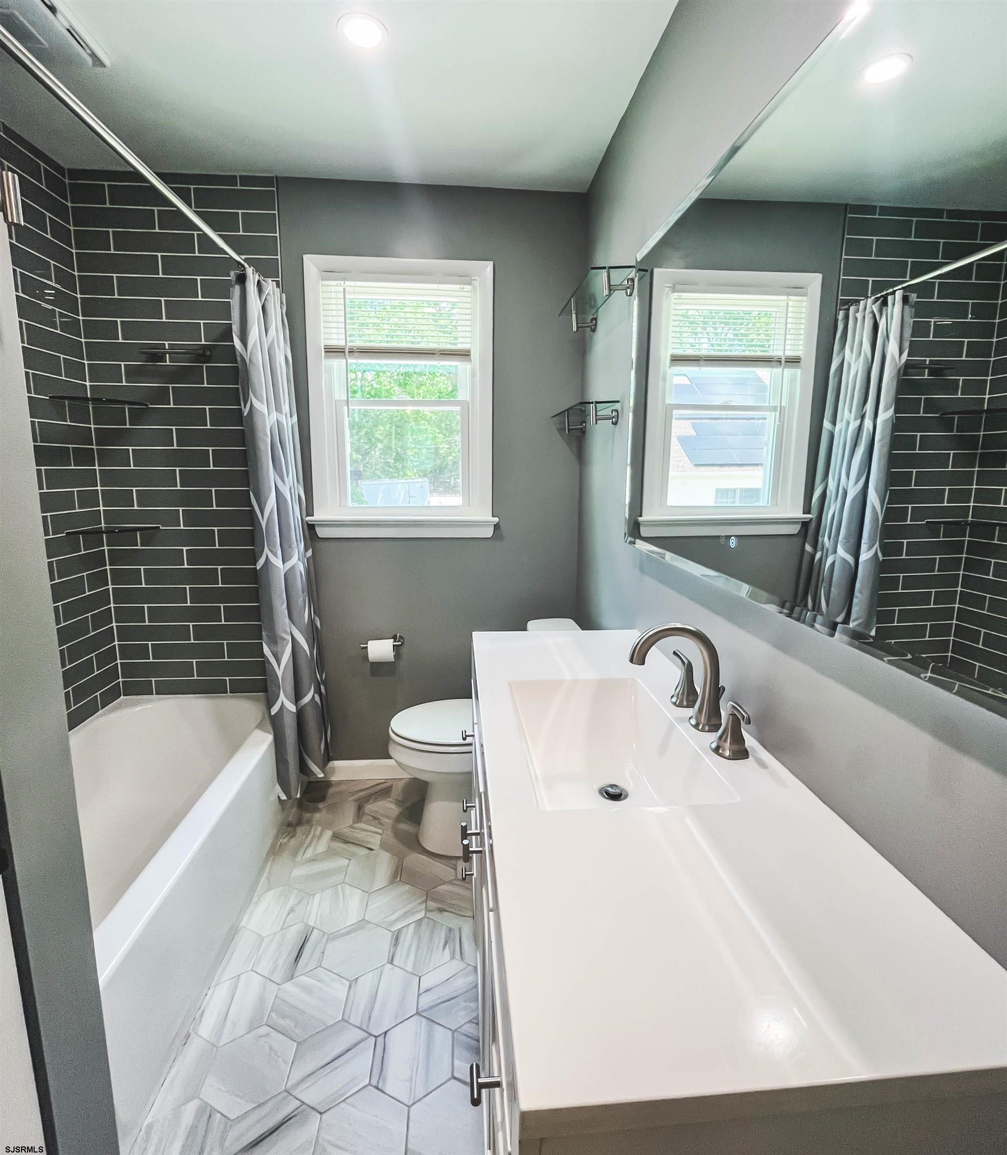 518 Delaware Avenue Absecon, NJ 08201 - Photo 19 of 38 a bathroom with a tub a sink a toilet and a shower