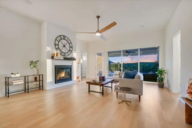 a living room with furniture a fireplace and a floor to ceiling window
