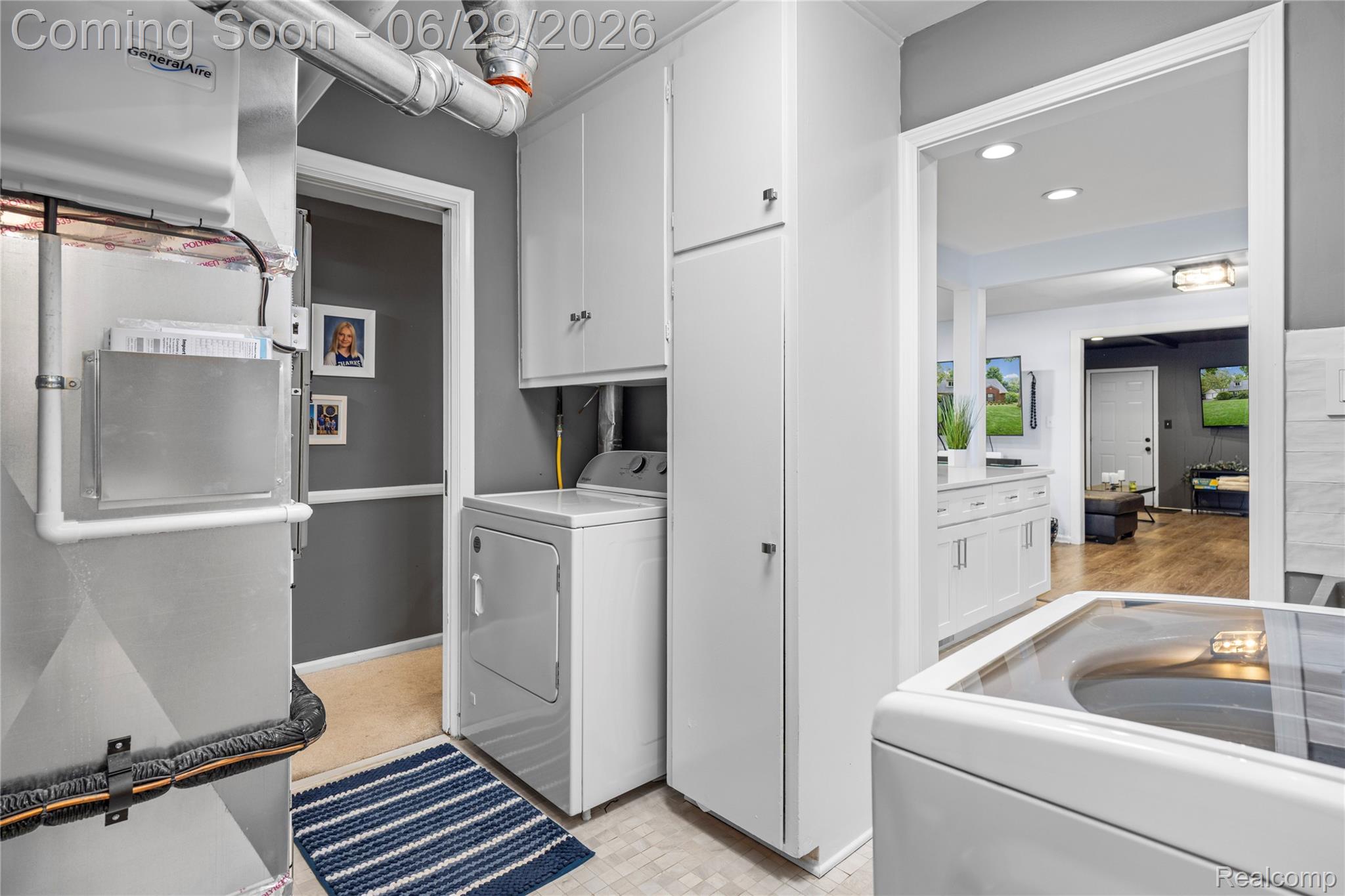 6085 Worlington Road Bloomfield Hills, MI 48301 - Photo 43 of 75 Dedicated utility space featuring a washer and dryer, white cabinetry, and an adjacent built-in storage unit