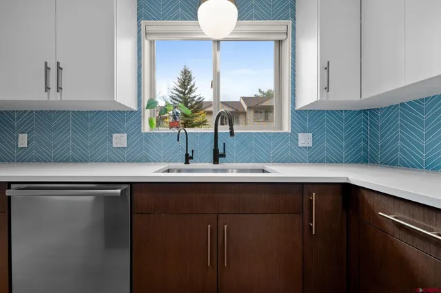 a kitchen with a sink and a potted plant