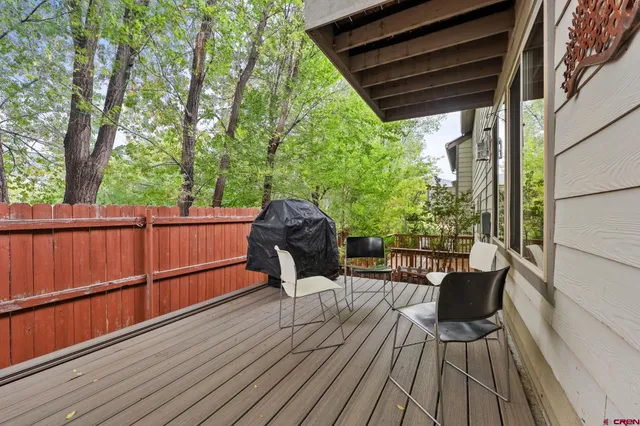 a view of deck with furniture and trees in the front