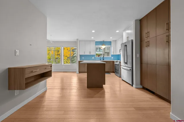 a kitchen with stainless steel appliances a refrigerator and a stove top oven