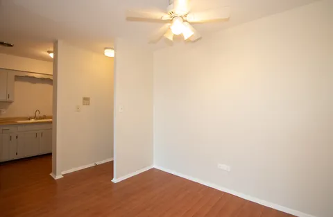 a view of a kitchen with wooden floor and a ceiling fan