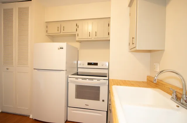 a kitchen with a white cabinets and white appliances