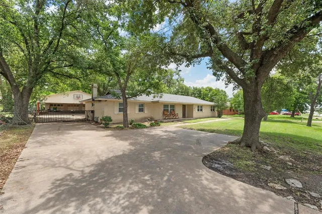 a front view of a house with a yard and tree