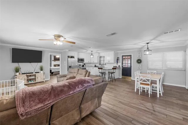 a living room with furniture wooden floor and a flat screen tv