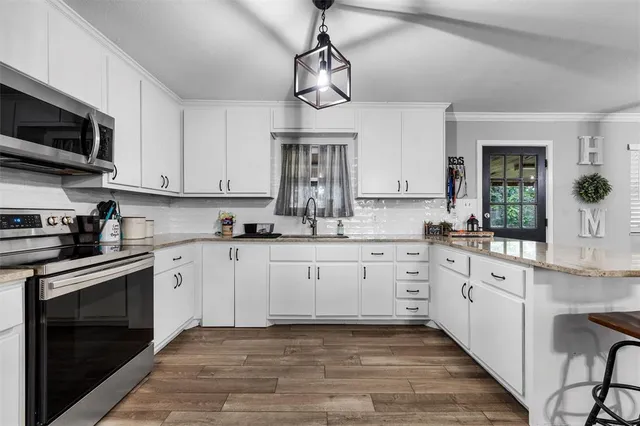 a kitchen with stainless steel appliances granite countertop a sink and cabinets