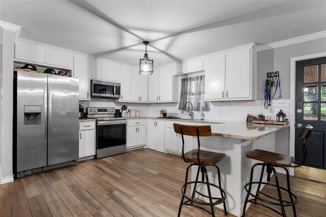 a kitchen with stainless steel appliances a stove a sink refrigerator and cabinets