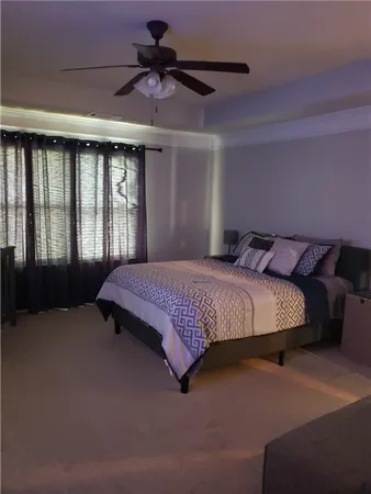 a bedroom with a bed mirror and a ceiling fan