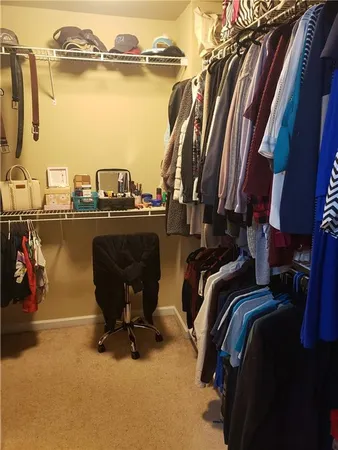 a view of walk in closet with clothes and shoes