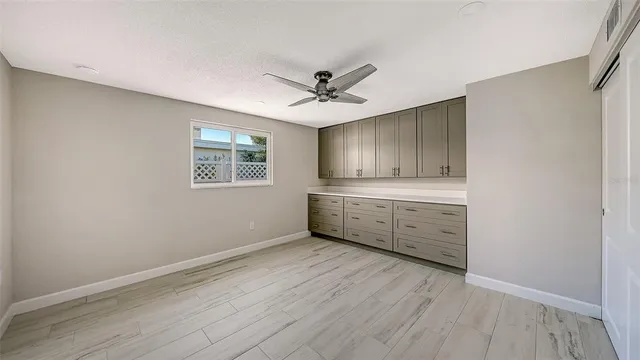 a view of a kitchen with wooden floor and a ceiling fan