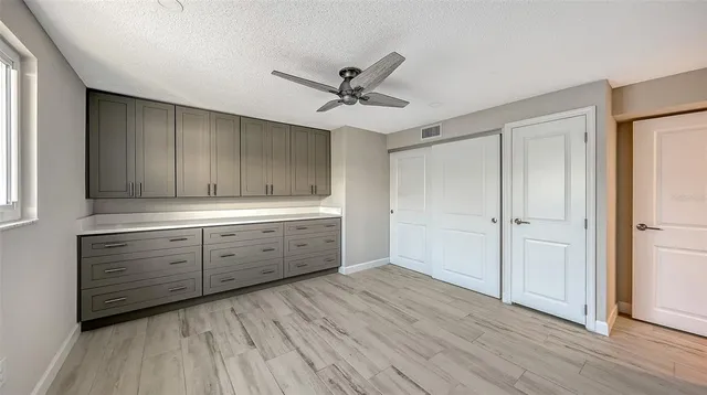 a room with a bed cabinets and a window