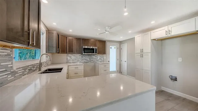 a kitchen with stainless steel appliances a refrigerator sink and microwave