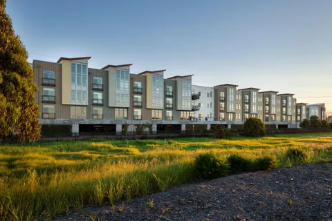 a view of a swimming pool next to a lake with tall buildings