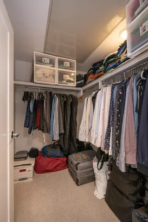 a view of walk in closet with clothes and shoes