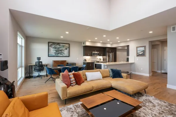 a living room with furniture and a view of kitchen