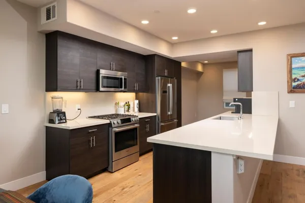 a kitchen with stainless steel appliances granite countertop a sink stove and refrigerator