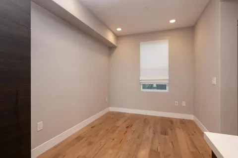 a view of empty room with wooden floor
