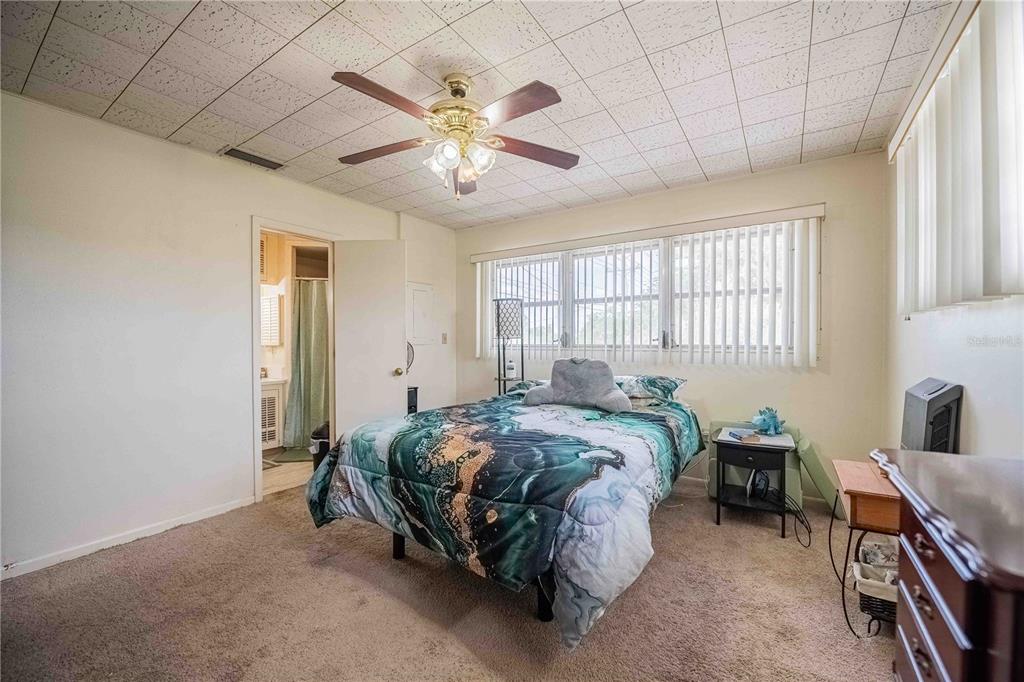 5110 Lakeland Highlands Road Lakeland, FL 33813 - Photo 15 of 40 a bedroom with a bed and a chandelier