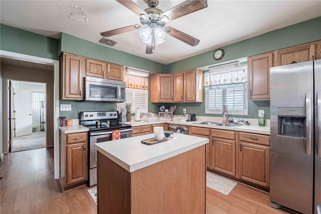 5110 Lakeland Highlands Road Lakeland, FL 33813 - Photo 9 of 40 a kitchen with stainless steel appliances granite countertop a stove top oven a sink dishwasher a refrigerator and a dining table with wooden floor