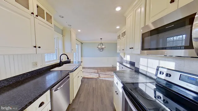 a kitchen with stainless steel appliances a sink stove and cabinets