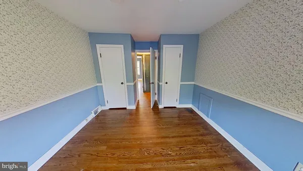 a view of an empty room with wooden floor