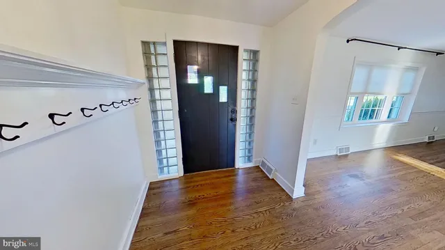 an empty room with windows and wooden floor