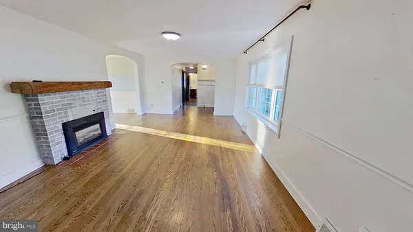 a view of a livingroom with wooden floor and a fireplace