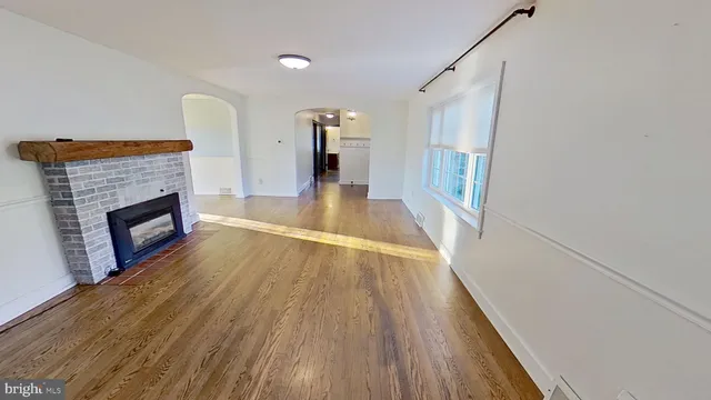 a view of a livingroom with wooden floor and a fireplace
