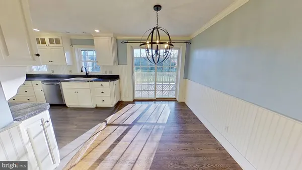 a kitchen with granite countertop a stove top oven a sink and a wooden floor