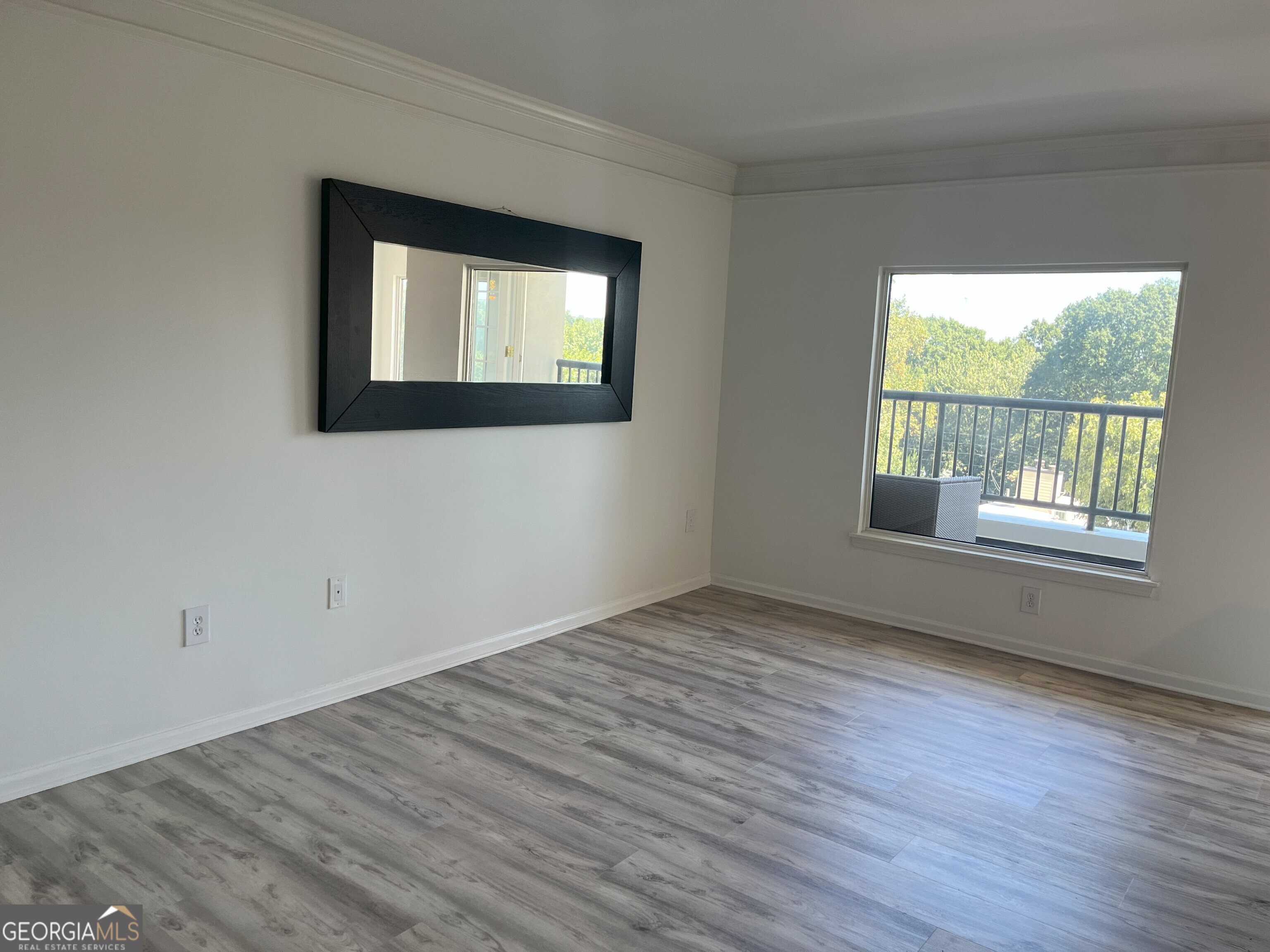 275 13th Street Northeast, Unit 605 Atlanta, GA 30309 - Photo 2 of 13 a view of an empty room with wooden floor and a window