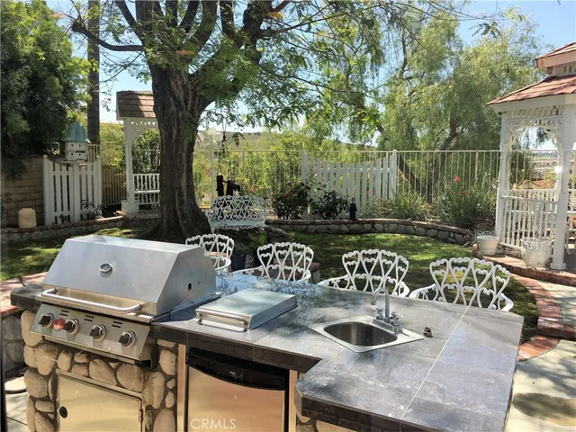 a roof deck with table and chairs and potted plants
