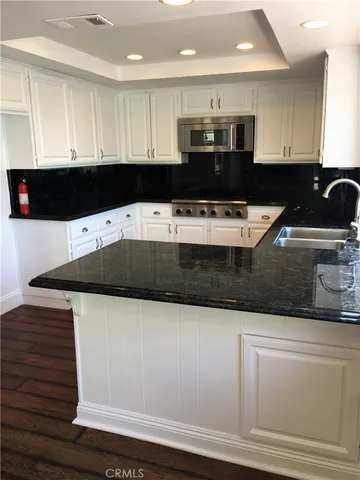 a kitchen with stainless steel appliances granite countertop a sink and a stove