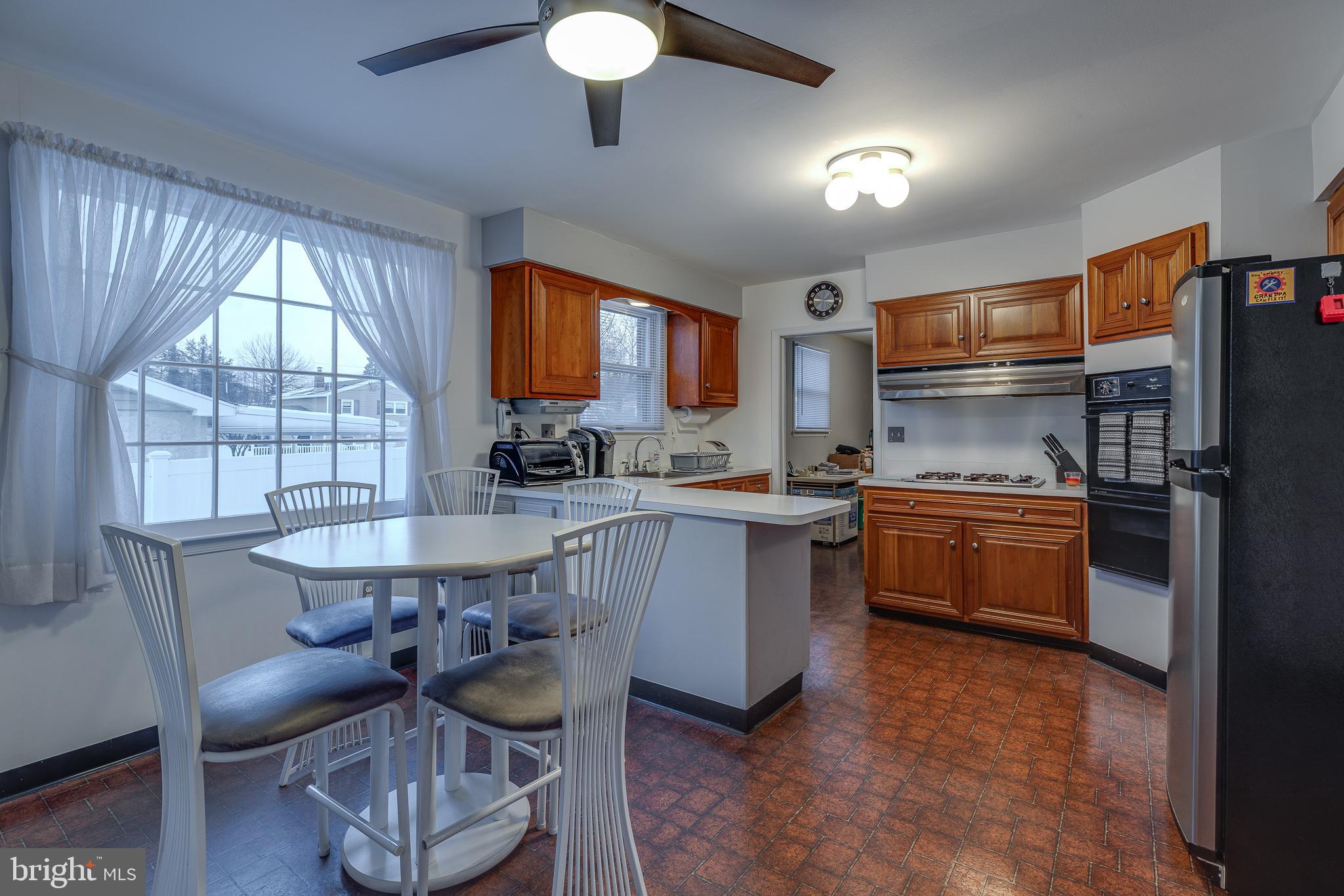 10963 Kipling Lane Philadelphia, PA 19154 - Photo 16 of 39 a kitchen with stainless steel appliances granite countertop a stove a sink dishwasher a microwave oven and a dining table with wooden cabinet