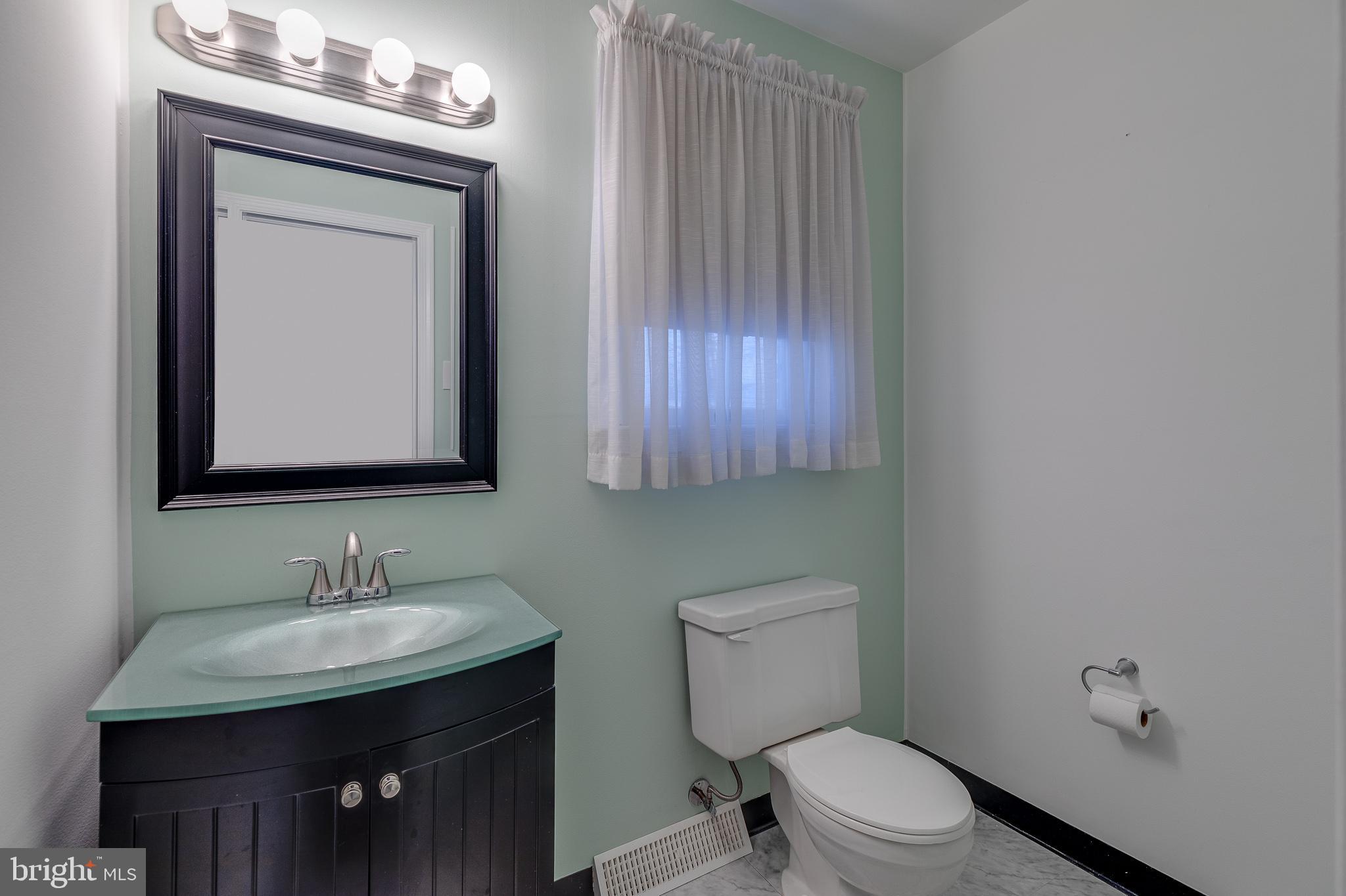 10963 Kipling Lane Philadelphia, PA 19154 - Photo 20 of 39 a bathroom with a toilet a sink a mirror and vanity