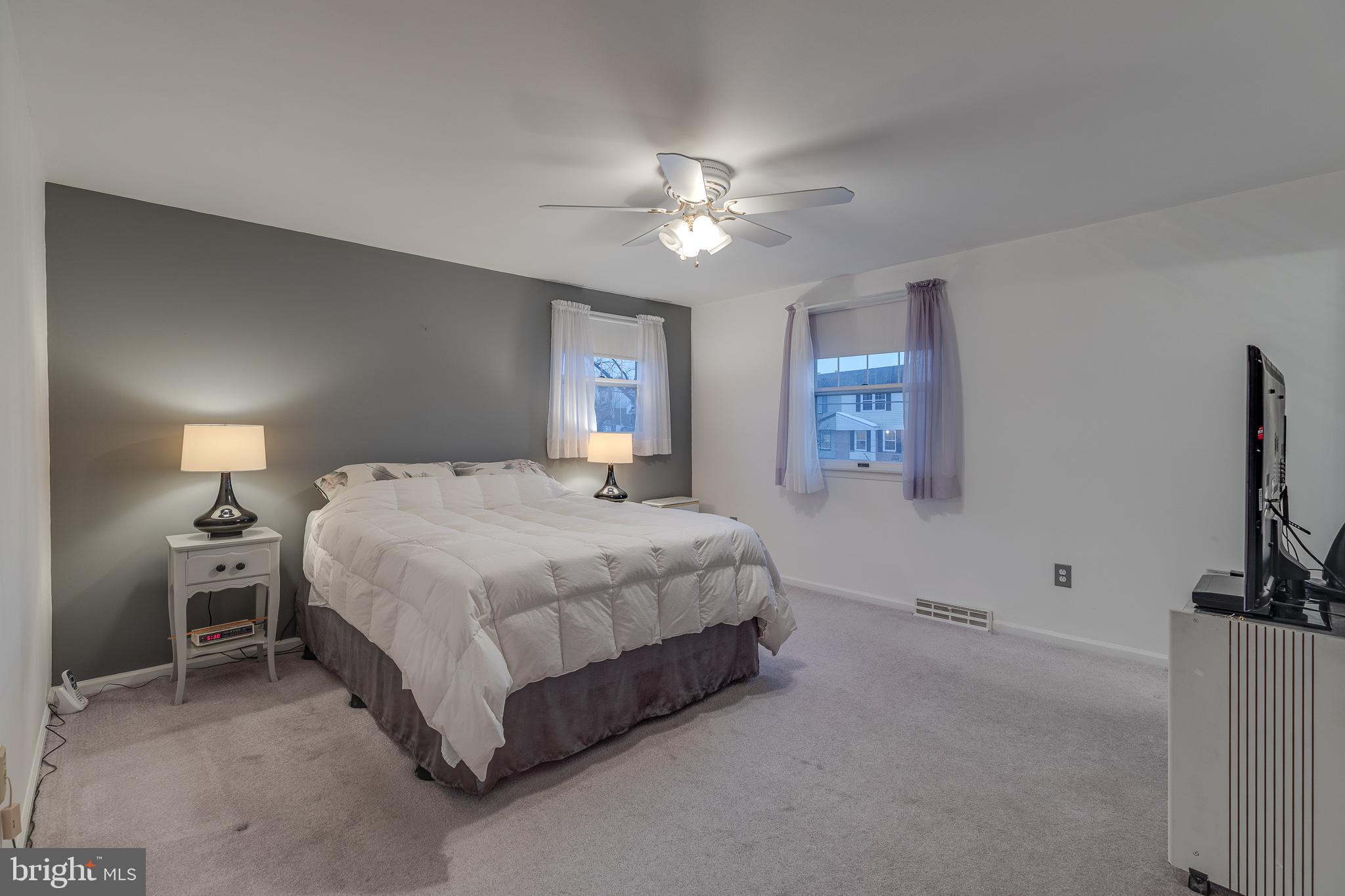 10963 Kipling Lane Philadelphia, PA 19154 - Photo 32 of 39 a bedroom with a bed and a ceiling fan with a chair