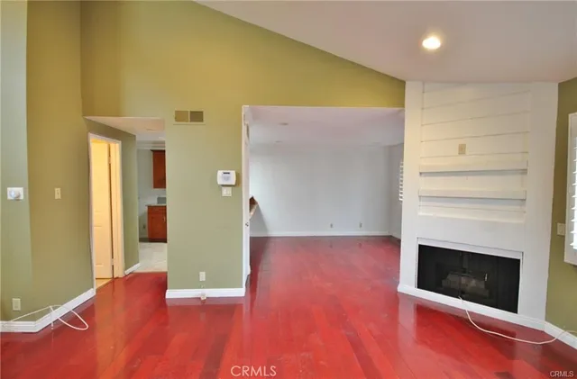 a view of a livingroom with wooden floor and a fireplace