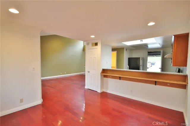 a view of an empty room with window and wooden floor