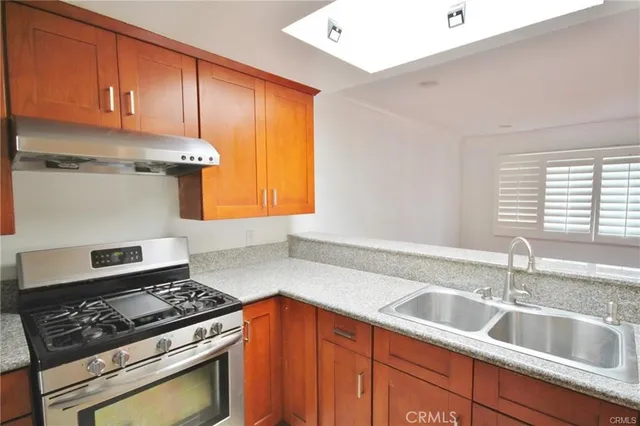 a kitchen with stainless steel appliances granite countertop a sink stove and cabinets