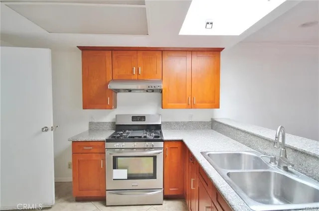 a kitchen with stainless steel appliances granite countertop a sink stove and cabinets