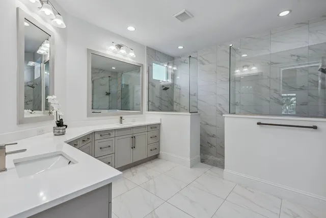 a large bathroom with a double vanity sink a large mirror and a shower