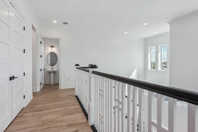 a view of a hallway with wooden floor and windows