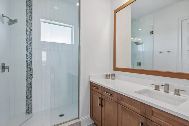a bathroom with a shower sink and mirror