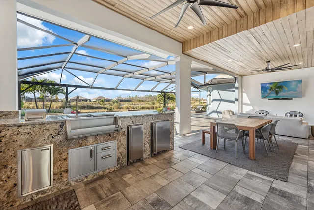 a open kitchen with a sink a stove and chairs