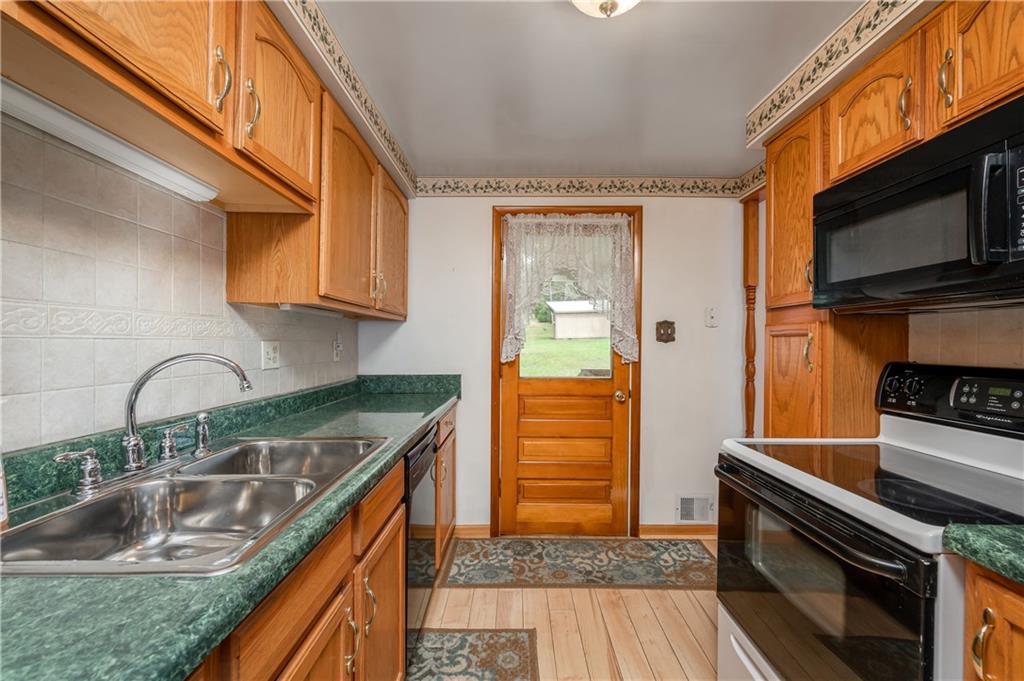 232 Pflugh Road Butler, PA 16001 - Photo 8 of 24 a kitchen with stainless steel appliances granite countertop a sink and a stove