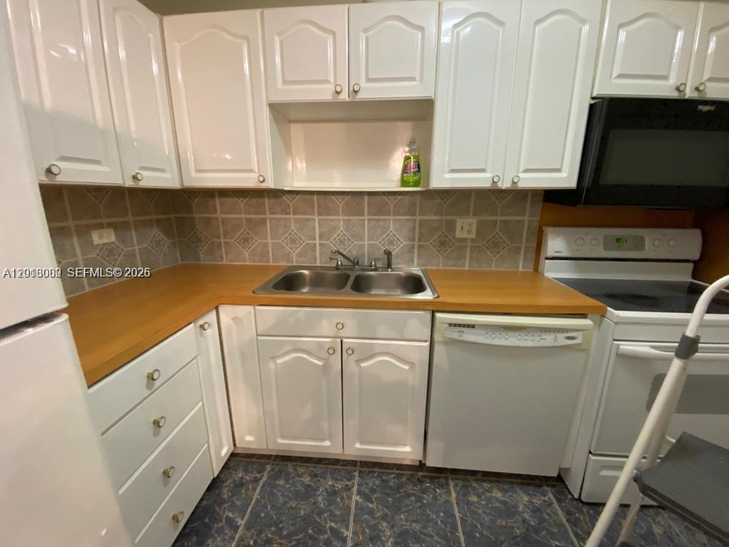 3730 Inverrary Drive, Unit 3B Lauderhill, FL 33319 - Photo 35 of 50 a kitchen with a sink and cabinets