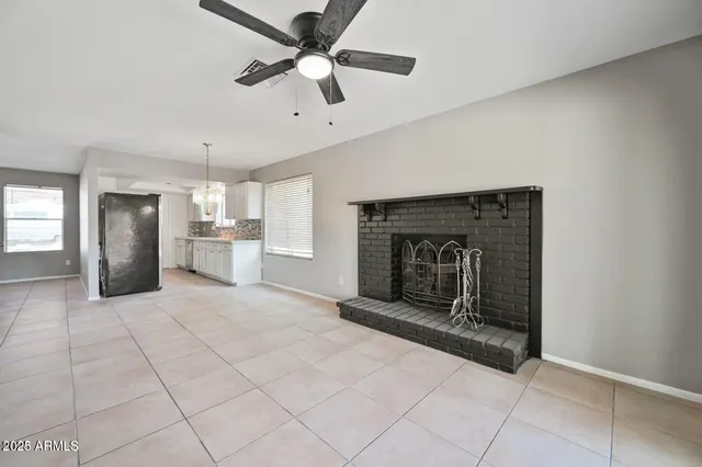 a view of a livingroom with a fireplace and a ceiling fan