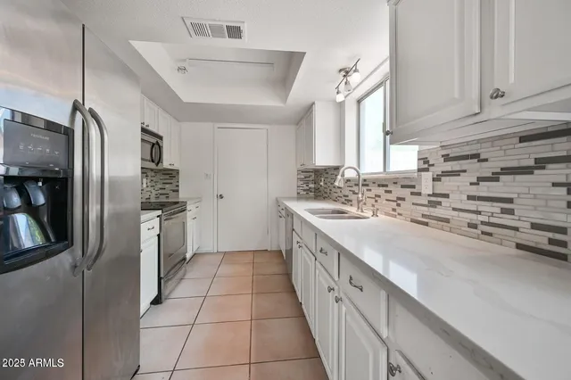 a kitchen with stainless steel appliances a sink stove and refrigerator