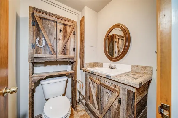 a bathroom with a toilet a sink and a mirror